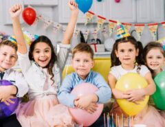 Children laughing and playing party games at colorful 8th birthday celebration with balloons and decorations