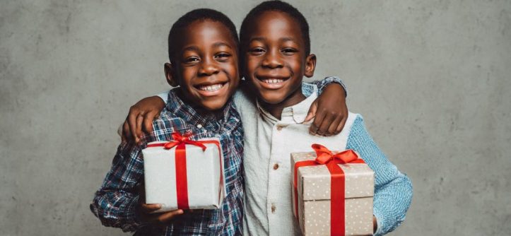 1. Two brothers embracing and smiling with gift boxes between them symbolizing long distance sibling connection