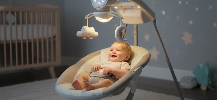 A happy baby relaxing in a modern smart baby swing with soft lights and gentle motion
