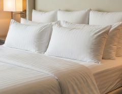 Fluffy white luxury hotel pillows arranged on bed with high-quality linens