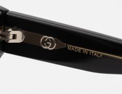 Close-up of authentic Gucci sunglasses showing double-G logo engraving and Made in Italy stamp